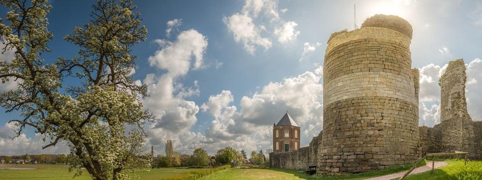 De ruïnes van kasteel Montfort, met de zon op de achtergrond, is één van de kastelen die je tegenkomt op de fietsroutes langs kastelen, burchten en landhuizen