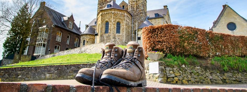 Putting hiking shoes on the wall in front of the Basilica in Sint Odiliënberg during autumn hikes