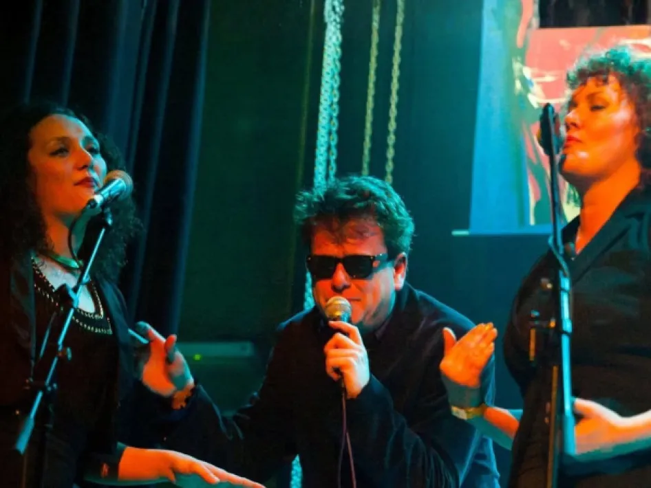 Band ChaCha brengt tijdens 25 jaar zonder Brood een muzikaal eerbetoon aan Herman Brood, met zanger en twee achtergrondzangeressen op het podium.