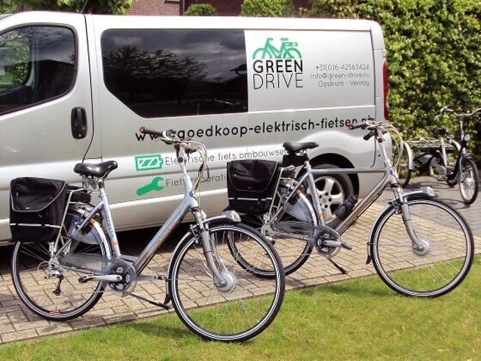 Het busje van Green - Drive fietsenwinkel in Oostrum met op de voorgrond 2 fietsen