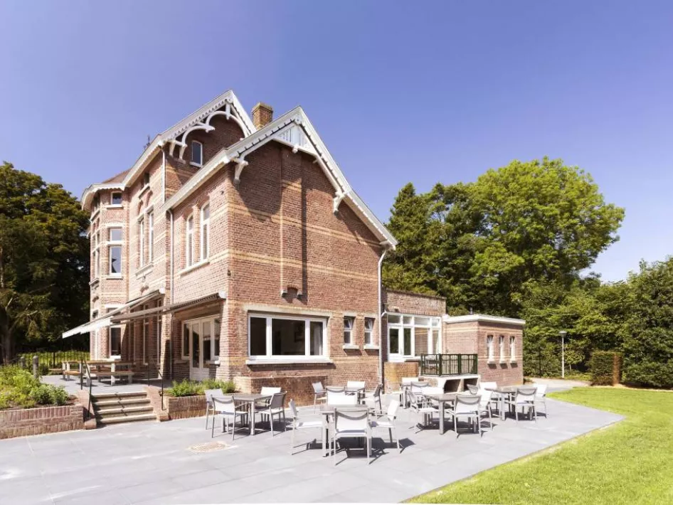Het mooie statige pand van Villa Venray met een terrasje op de voorgrond