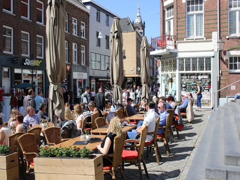 Het terras gevuld met mensen die in de zon zirren. 