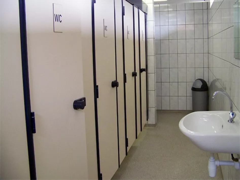 Gepflegte und moderne Sanitäranlage auf dem Campingplatz Straoterhof mit mehreren Toilettenkabinen und einem weißen Waschbecken.