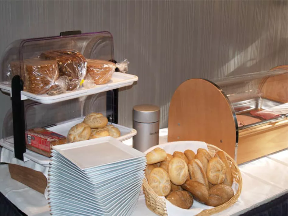 Gemütliches Doppelzimmer mit zwei Federkernbetten, gelben Zierkissen und warmer Beleuchtung.