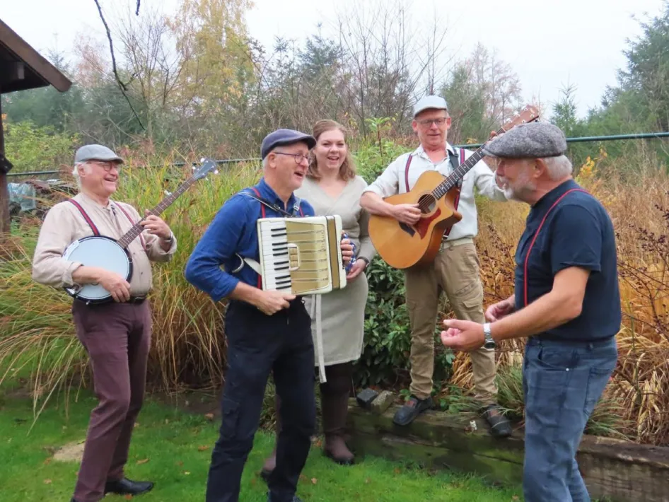 Peelpodium: De groep LIATH treedt op in een groene omgeving. De bandleden spelen verschillende instrumenten.