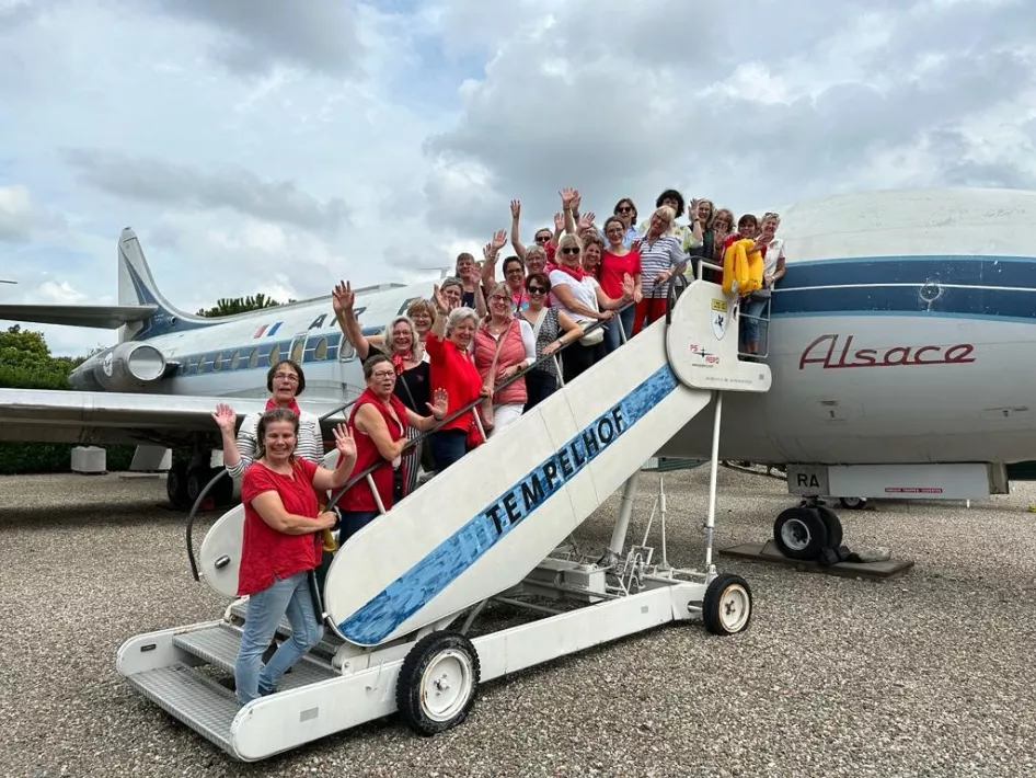 Groep poseert op de trap bij het Air France vliegtuig van Vliegtuigpark PS Aero