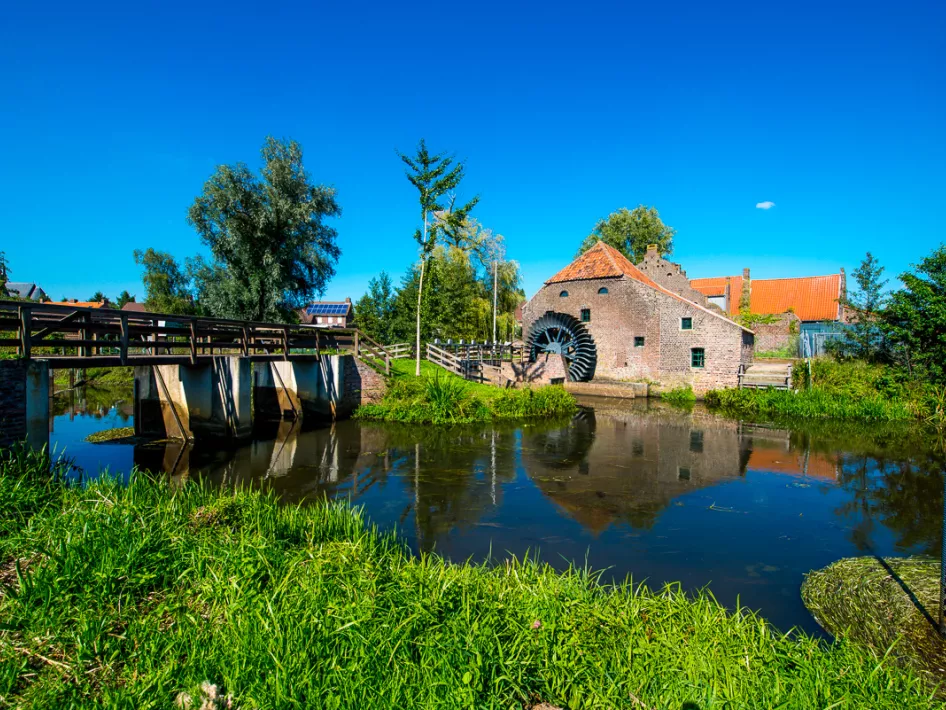 Brug over het water met een boerderij op de achtergrond