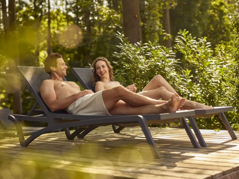 Man en vrouw liggen op de ligbedden.