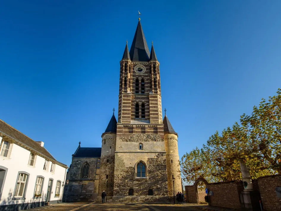 De Abdijkerk Thorn met haar kenmerkende toren en gotische ramen, gefotografeerd op een zonnige dag met blauwe lucht.