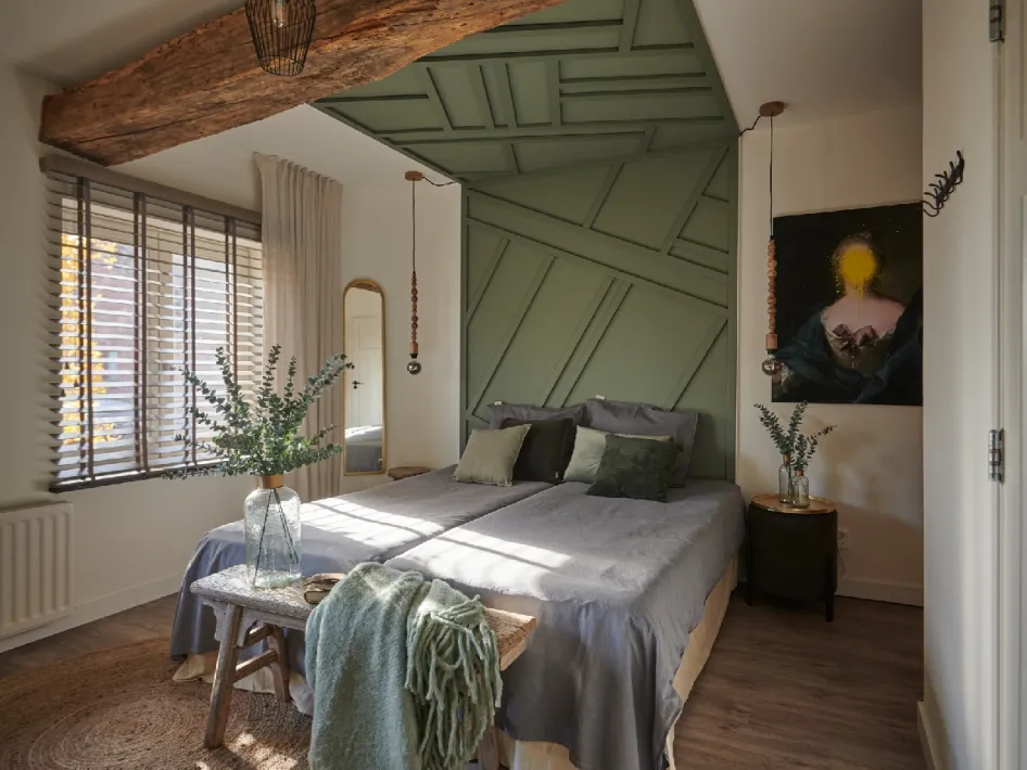 Comfortabele tweepersoonskamer met groen accent en houten balken, te boeken bij B&B den Engel.