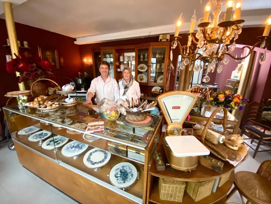 Bakker Ard Gerards en zijn vrouw May achter de toonbank van Beleefbakkerij Gerards-Steeghs, omringd door oude bakkersspullen.