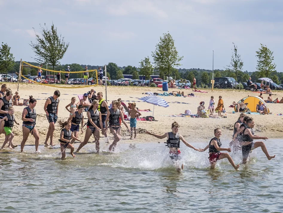 Kinderen rennen het water in op weg naar het Aquapark