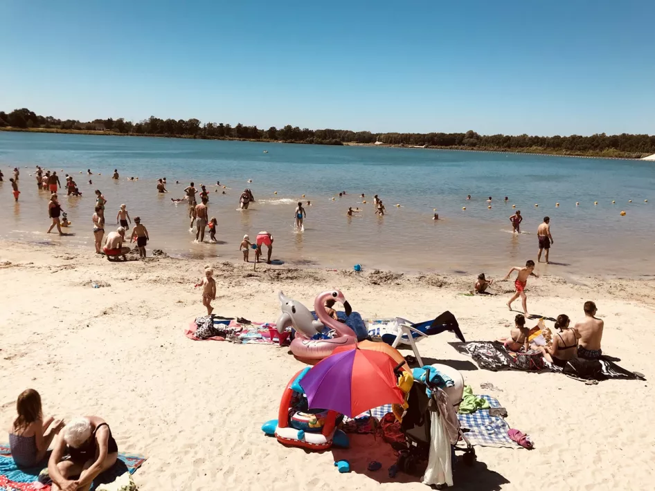 People sunbathe on the Blauwe Meertje beach and romp in the water