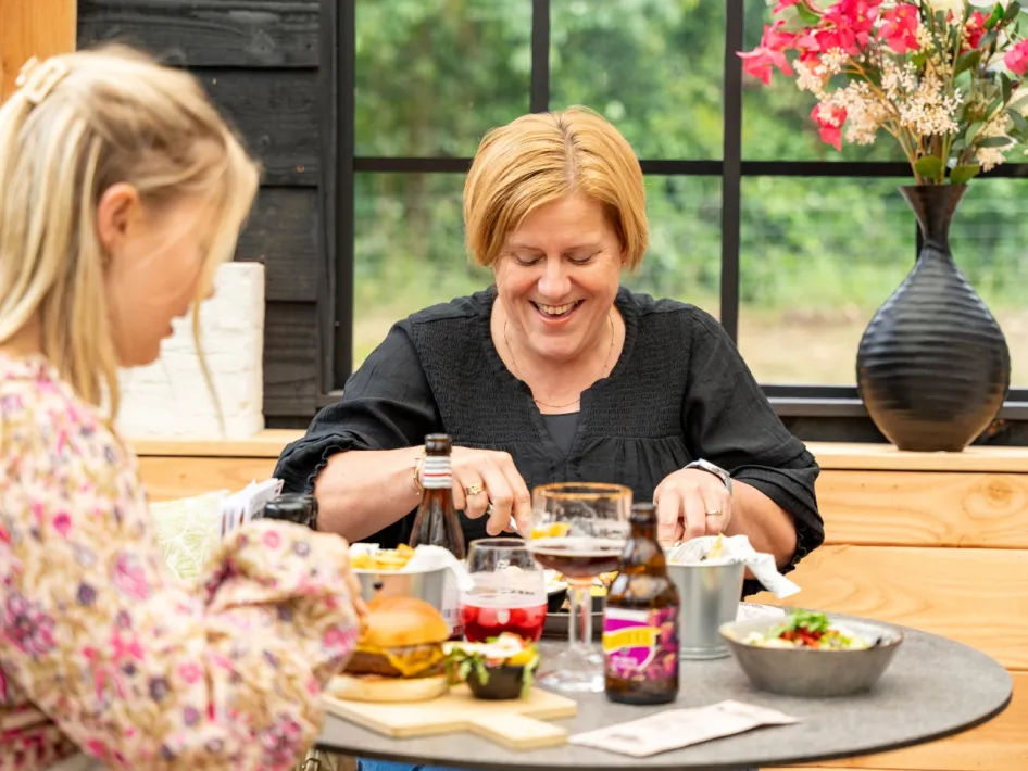 Im Waldcafé genießen Frau und Kind gemeinsam ein Mittagessen mit Limburger Produkten.