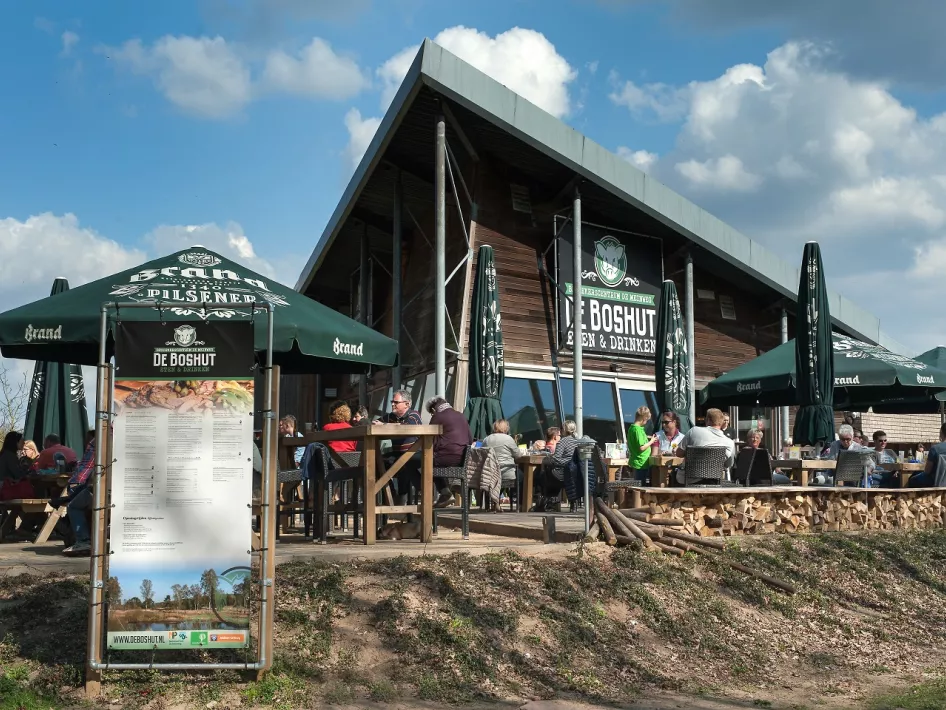 Brasserie de Boshut en het terras op een mooie zomerdag met mensen die aan het genieten zijn