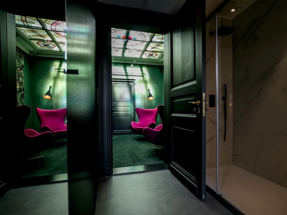 Seating area with design chairs and green walls at Boutique Hotel N10