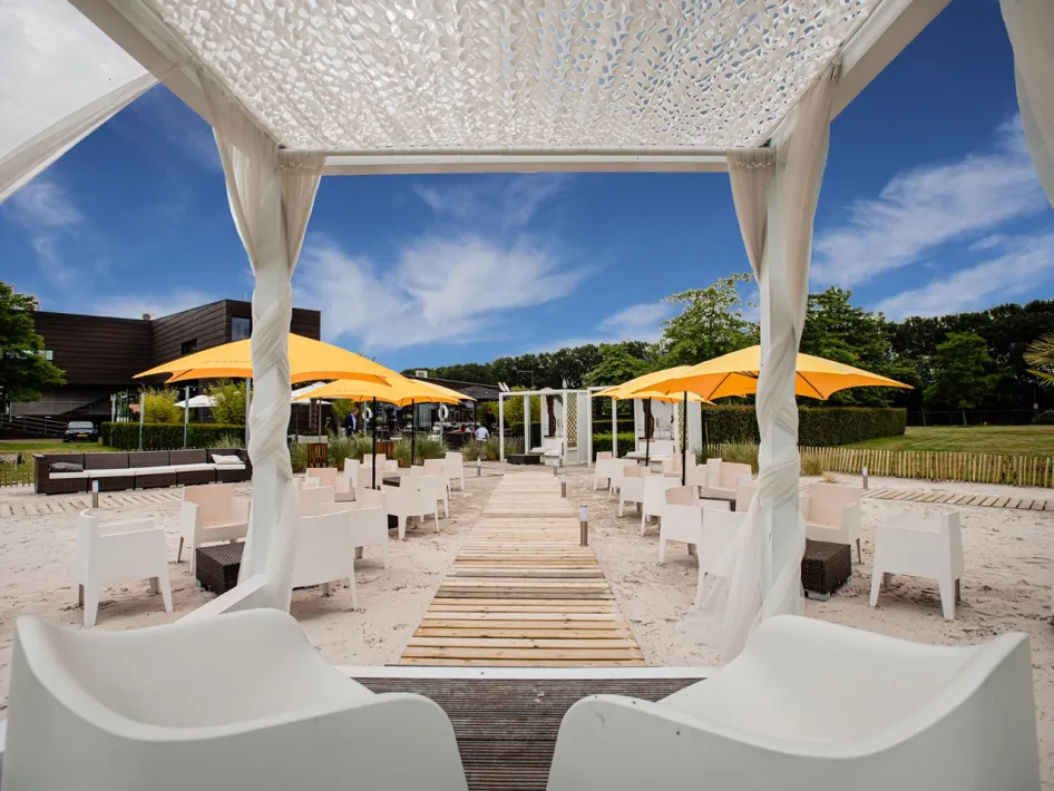 Zomers terras van Brasserie Boschmolenplas met witte zitplekken en gele parasols