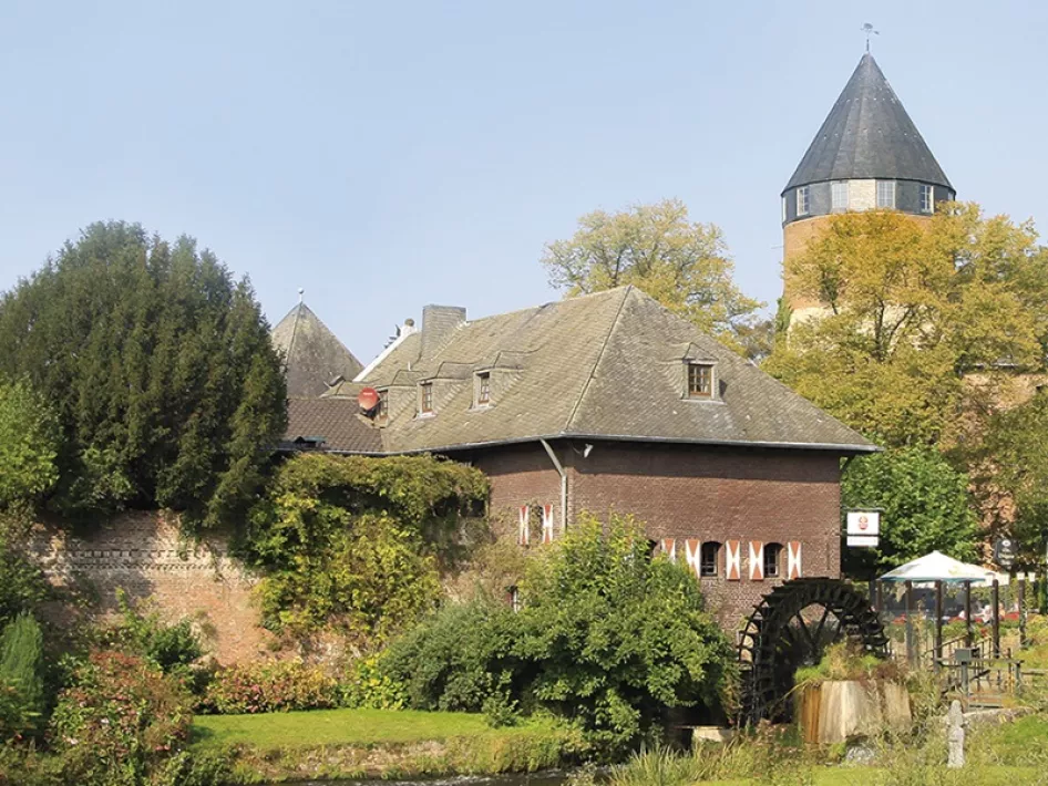 Die Wassermühle mit Burg Brüggen im Hintergrund
