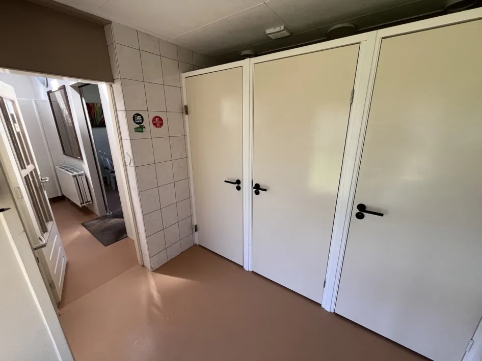 Net en verzorgd sanitairgebouw met toiletten en wastafels op de camperplaats.