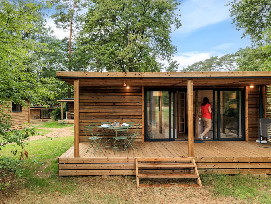 Set outdoor table on the porch of a wooden holiday home in the forest