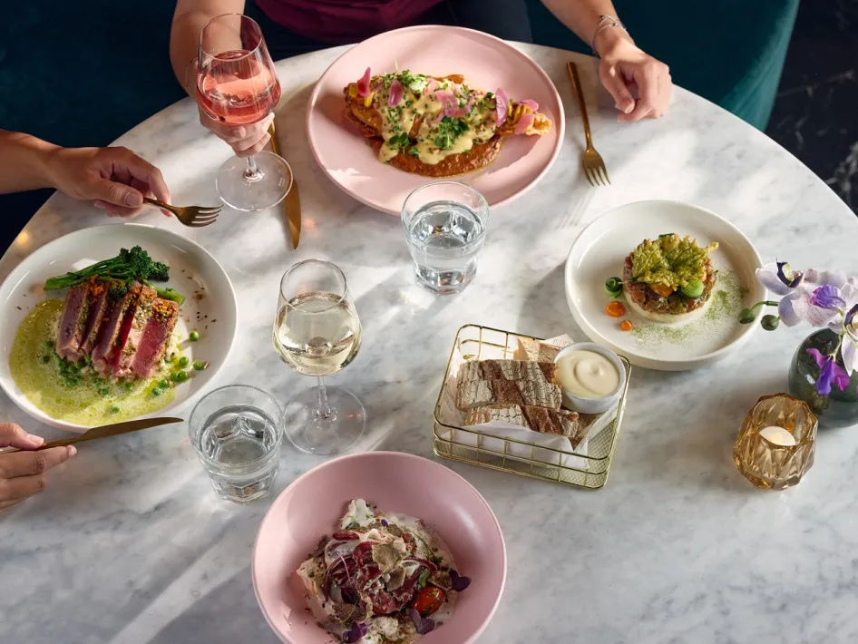 Various dishes on the table at Cerise Restaurant, served with bread, water and wine.