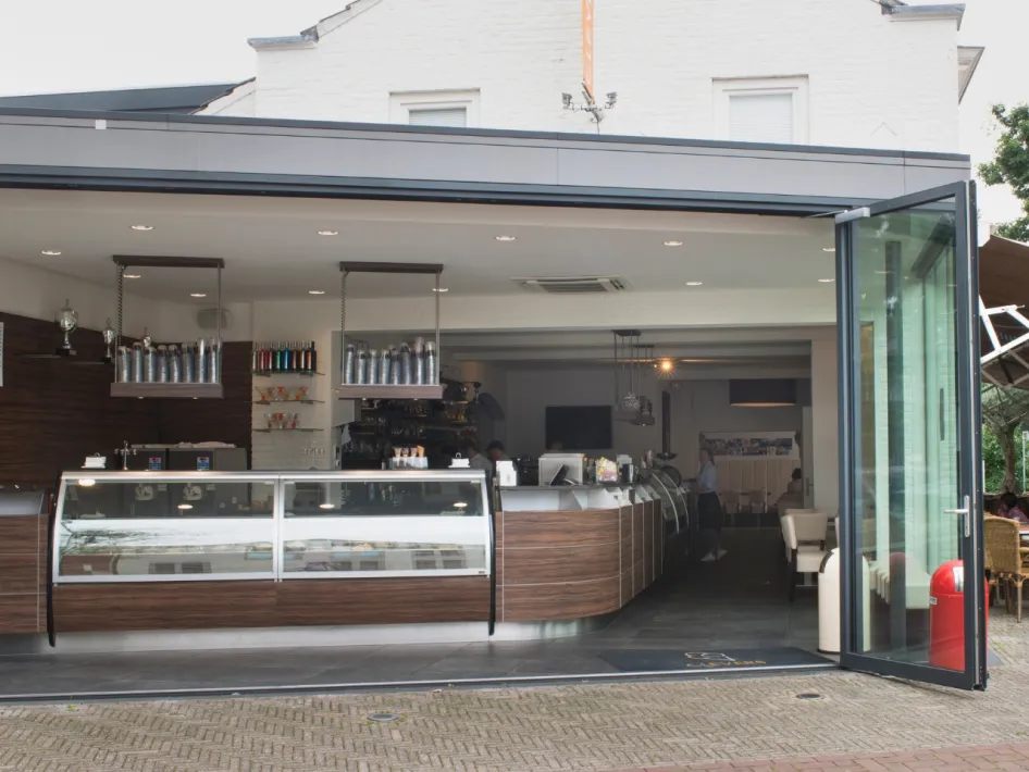 Large ice cream display case at the entrance of Ice Cream Parlor Clevers Overloon with open doors and a view of the terrace.