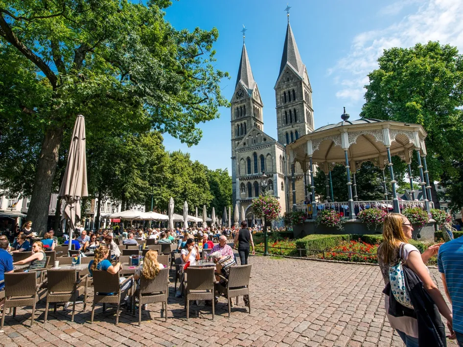 Munsterplein in Roermond met terrassen, kiosk en Munsterkerk, die je kunt bezoeken bij het Cuypersarrangement Roermond.