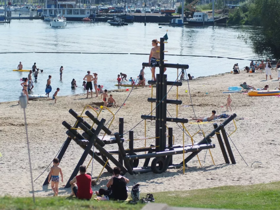 Kinderen spelen in het klimtoestel bij dagstrand De Steenberg