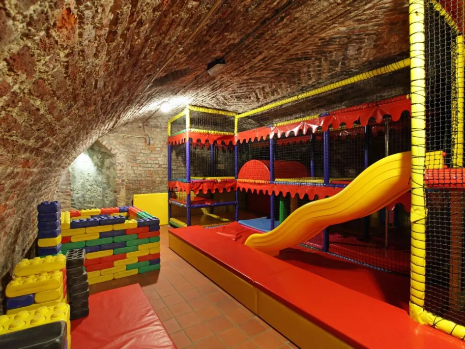 Indoor play cellar at De Pannekoekenbakker with climbing frame, slide and colourful play blocks for children.