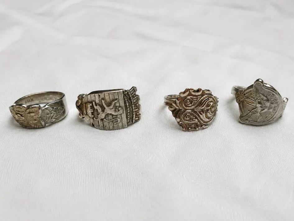 Vier zilveren ringen met verschillende sierlijke patronen, gemaakt van antieke lepeltjes.