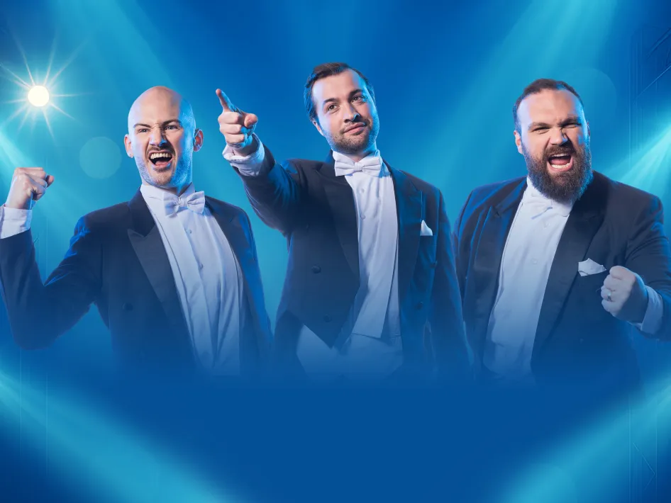 Drie mannen in rokkostuum poseren enthousiast onder blauw podiumlicht, met expressieve gezichten en krachtige gebaren.