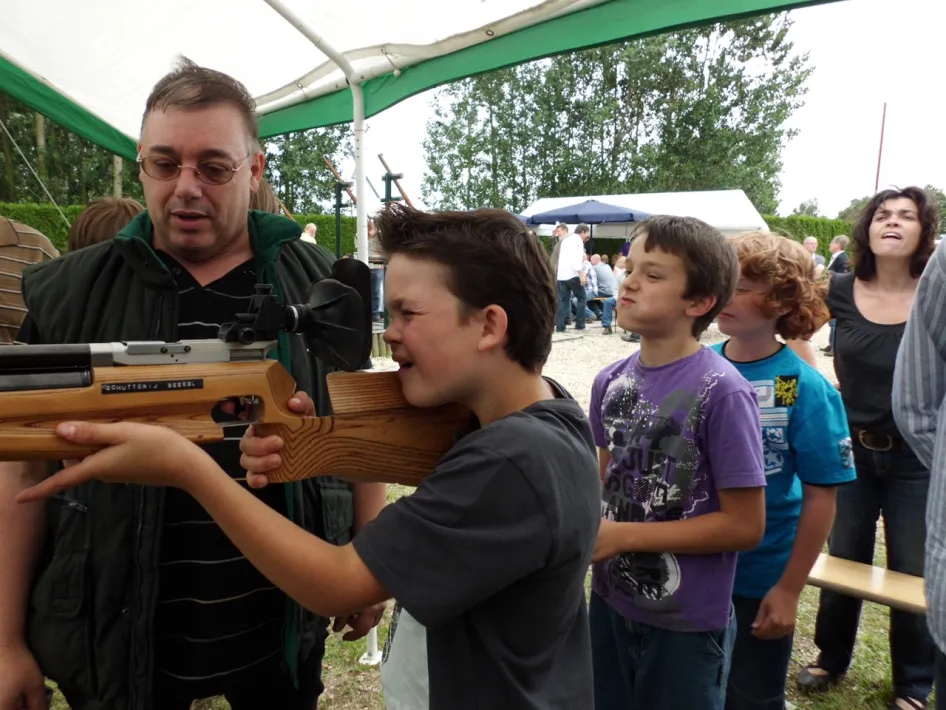 Jongen schiet met een luchtbuks tijdens het Dorpsschuttersfeest in Heel