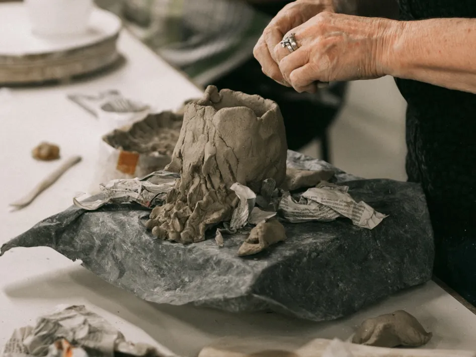 Deelnemer werkt met klei tijdens een workshop boetseren bij ECI Cultuurfabriek.