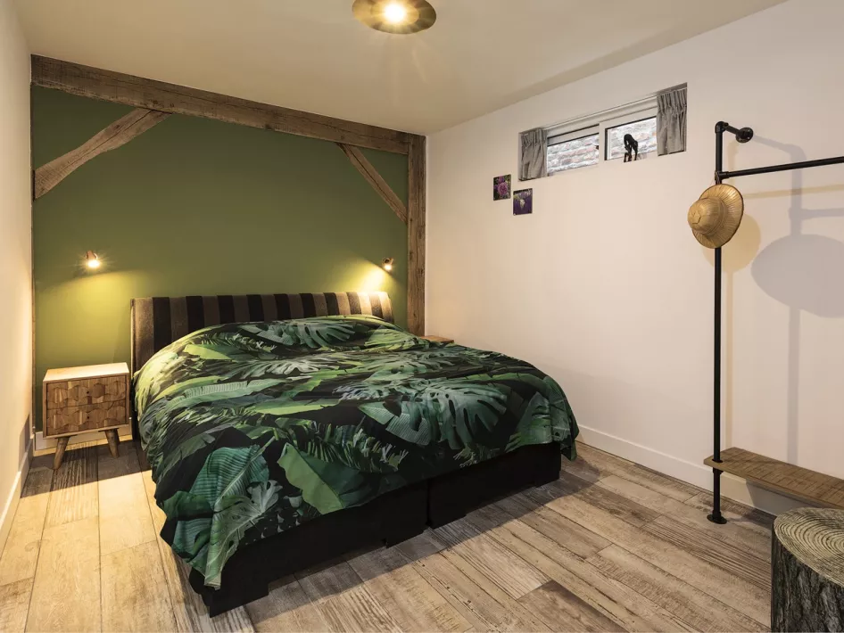 Gezellige slaapkamer in vakantieverblijf Eind 6, ingericht met een tweepersoonsbed en houten accenten.