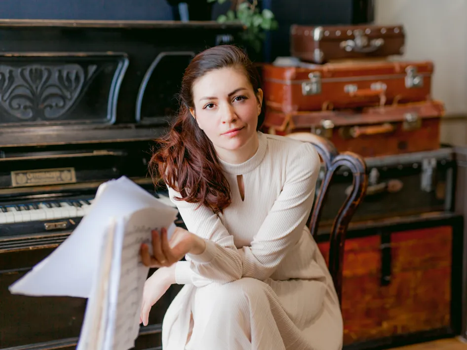 Ekaterina Litvintseva zittend voor een piano met partijen in haar hand