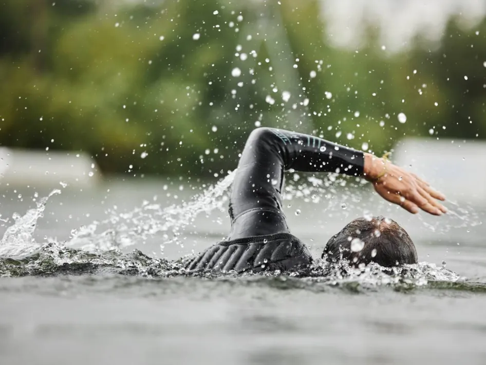 een man in zwempak zwemt in het open water tijdens Swim to Fight Cancer
