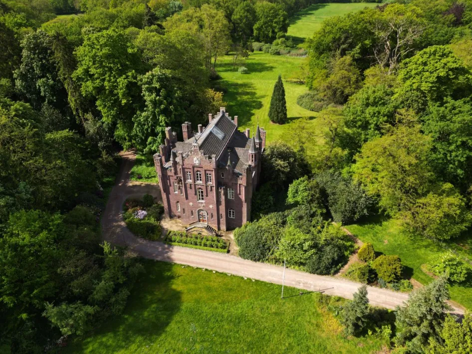 Luchtfoto van Kasteel Aerwinkel, omringd door groen parklandschap en bomen in Roerdalen. 