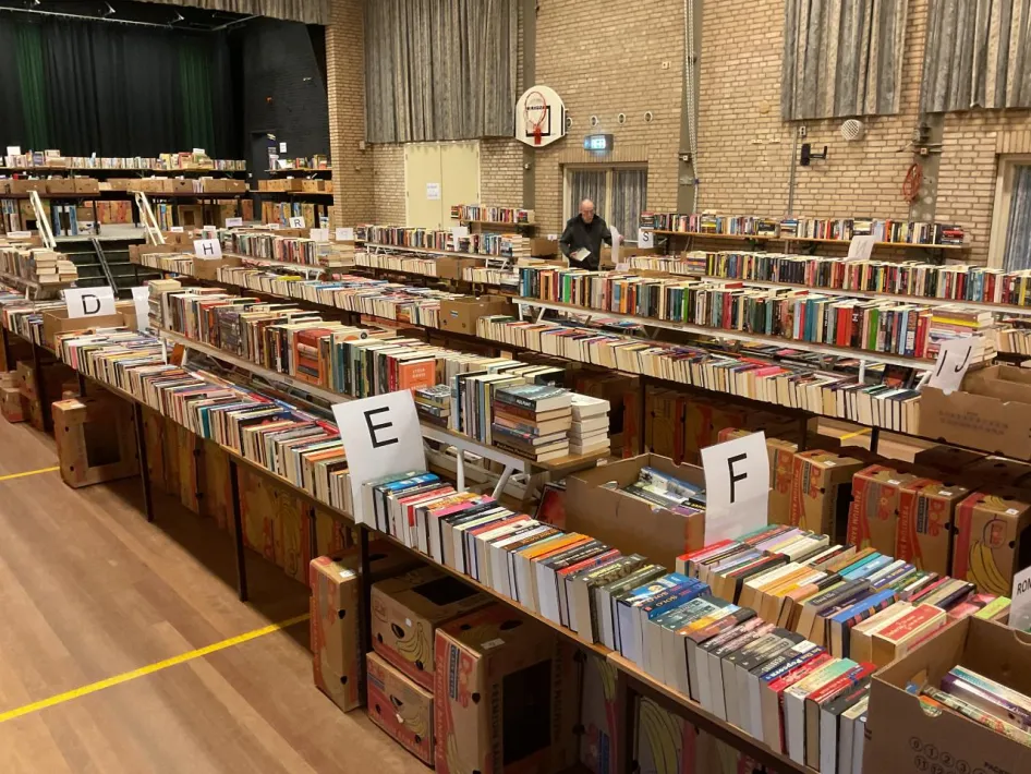 Grote Boekenmarkt met lange tafels vol gesorteerde boeken in Gemeenschapshuis Trefcentrum in Kelpen-Oler.