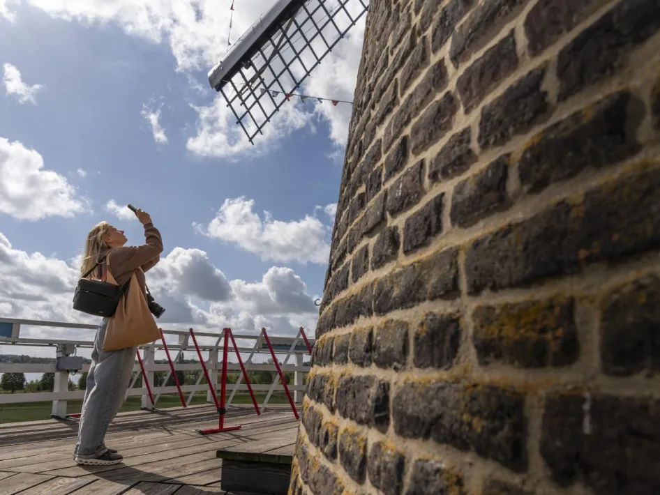 Open Monumentendag bij de Hompesche Molen - een vrouw staat op het balkon van de molen en neemt een foto met haar smartphone
