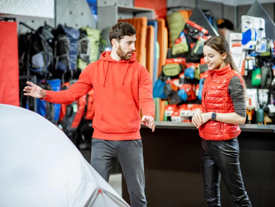 Kampeerdagen: een man en een vrouw staan voor een tent in een kampeerwinkel