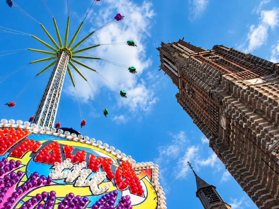 Zweefmolen naast de kerktoren in het centrum tijdens Kermis Weert.