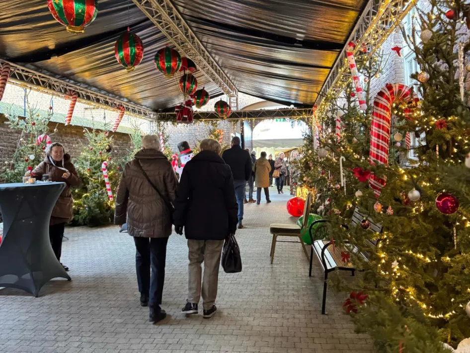 Bezoekers wandelen langs versierde kerstbomen en kerstverlichting bij de kerststal van de Zusters Birgittinessen in Weert.