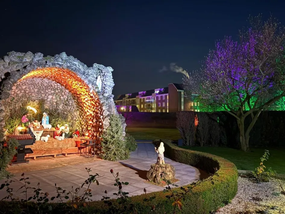 Verlichte kerststal van de Zusters Birgittinessen in Weert met het kerstverhaal uitgebeeld in een stenen grot.