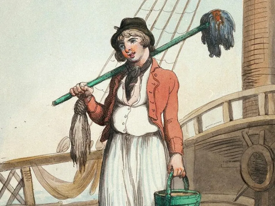 Jonge matroos in historische kleding staat op het dek van een zeilschip met een dweilstok over de schouder en een houten emmer in de hand.
