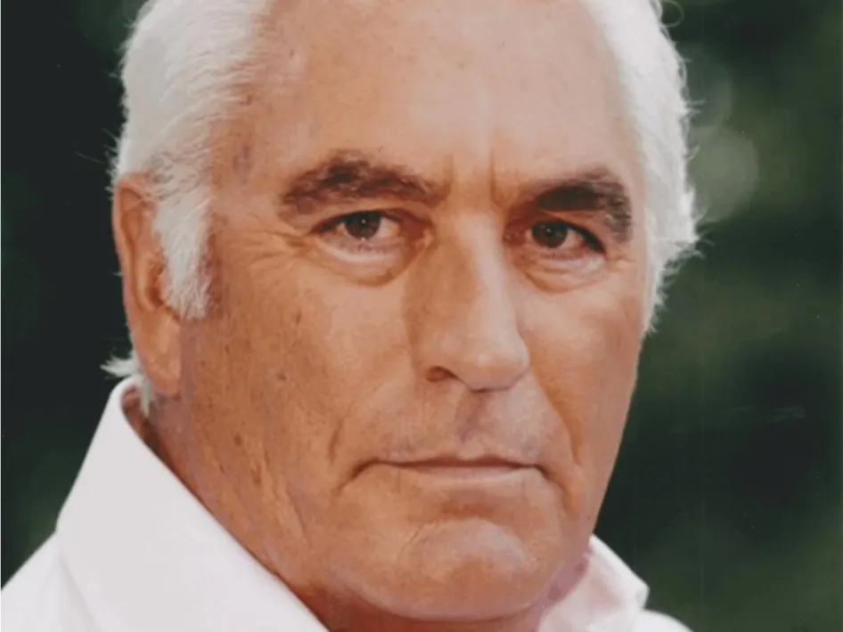 Bariton Marco Bakker in close-up portret met witte blouse en rustige achtergrond.