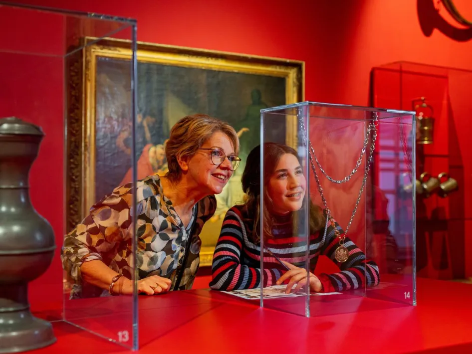 Bezoekers kijken aandachtig naar sieraden in een vitrine tijdens het museumweekend in Museum W