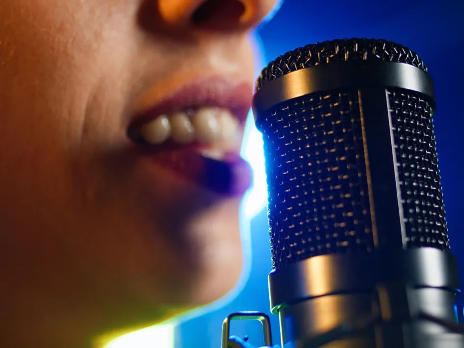 Close-up van een zangeres die zingt in een microfoon: zanggroep Blended Peelpodium