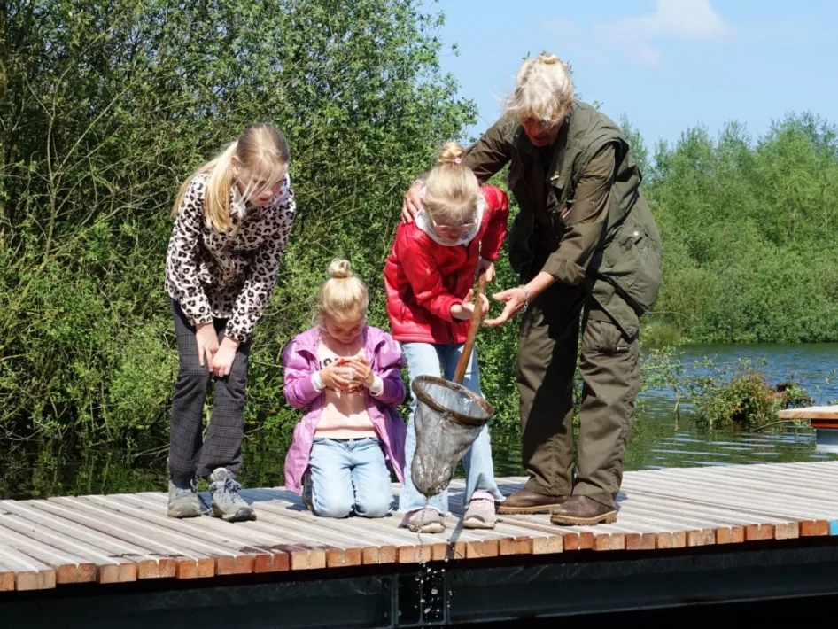 Kinderen en gids vangen waterdiertjes tijdens de sPeelse Beleeftocht op de Dag van het Nationaal Park in De Groote Peel.