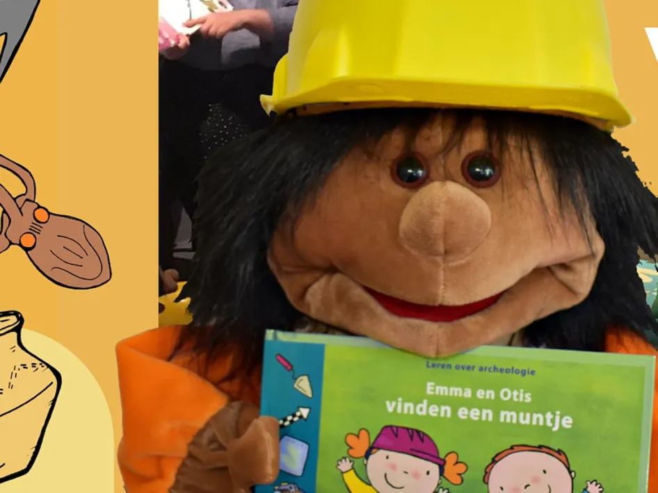 Handpop Archie met een archeologenhelm houdt het boek Emma en Otis vinden een muntje vast tijdens de Voorlees- en knutselsessie voor kleuters in het Regionaal Archeologisch Museum.