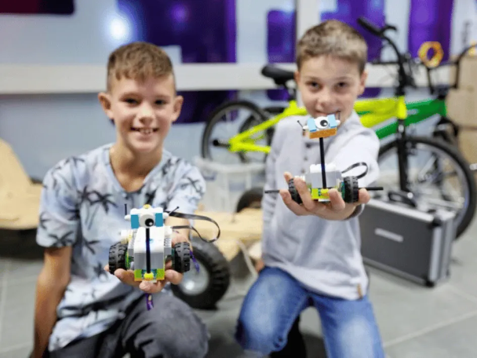 Zwei Jungen zeigen ihr Kunstwerk.